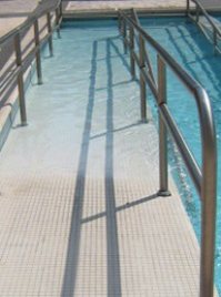 A handrailed access ramp running down into a swimming pool