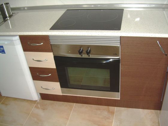 A fitted kitchen with a built-in oven and hob